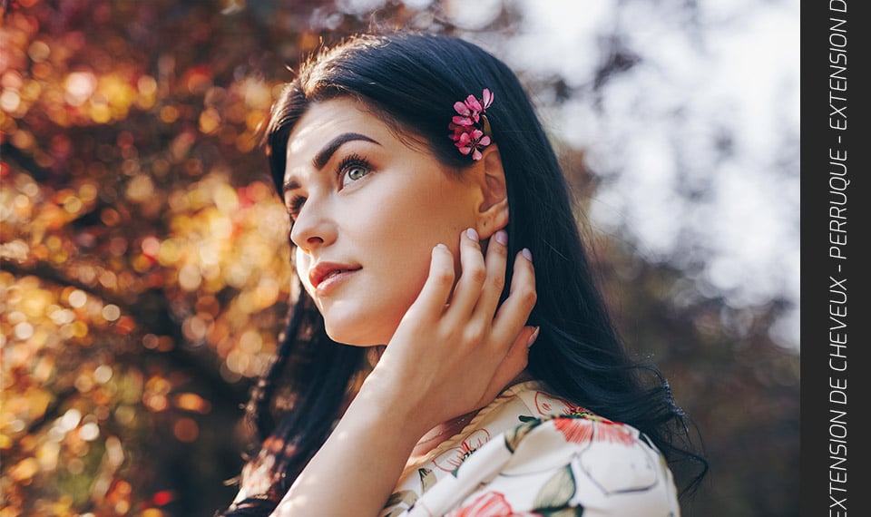 Femme qui porte des extensions de cheveux avec une fleur sur l'oreille